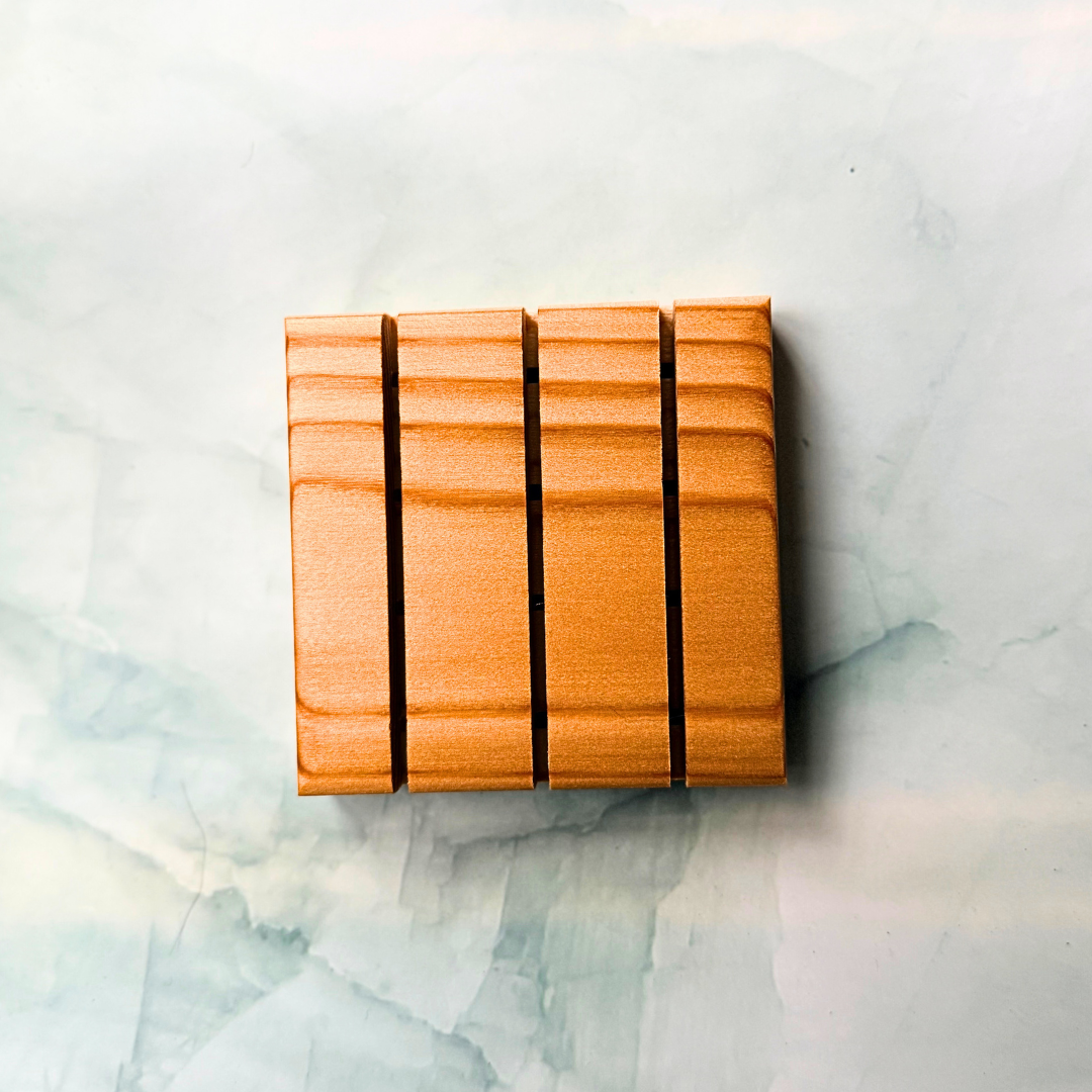 Wooden shower steamer tray with a striped pattern on a marble surface